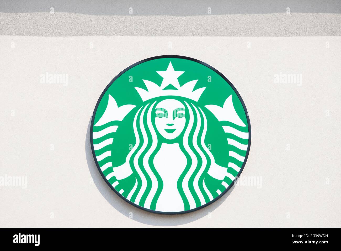Starbucks logo is on the outside wall of a building. Starbucks coffee shop. Stock Photo