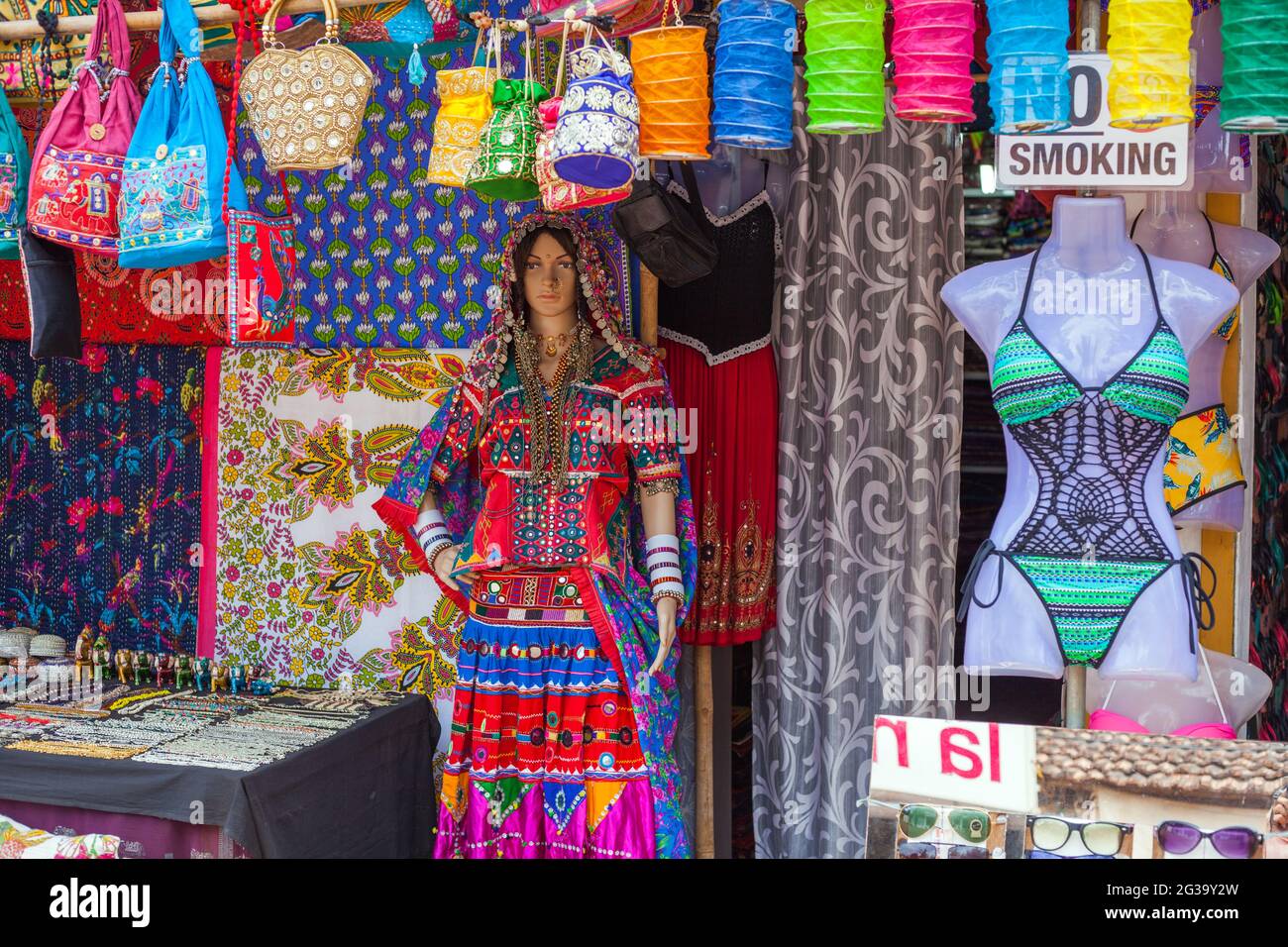 Female mannequin wearing colourful karnatakan clothing beside bikini outside fashion store