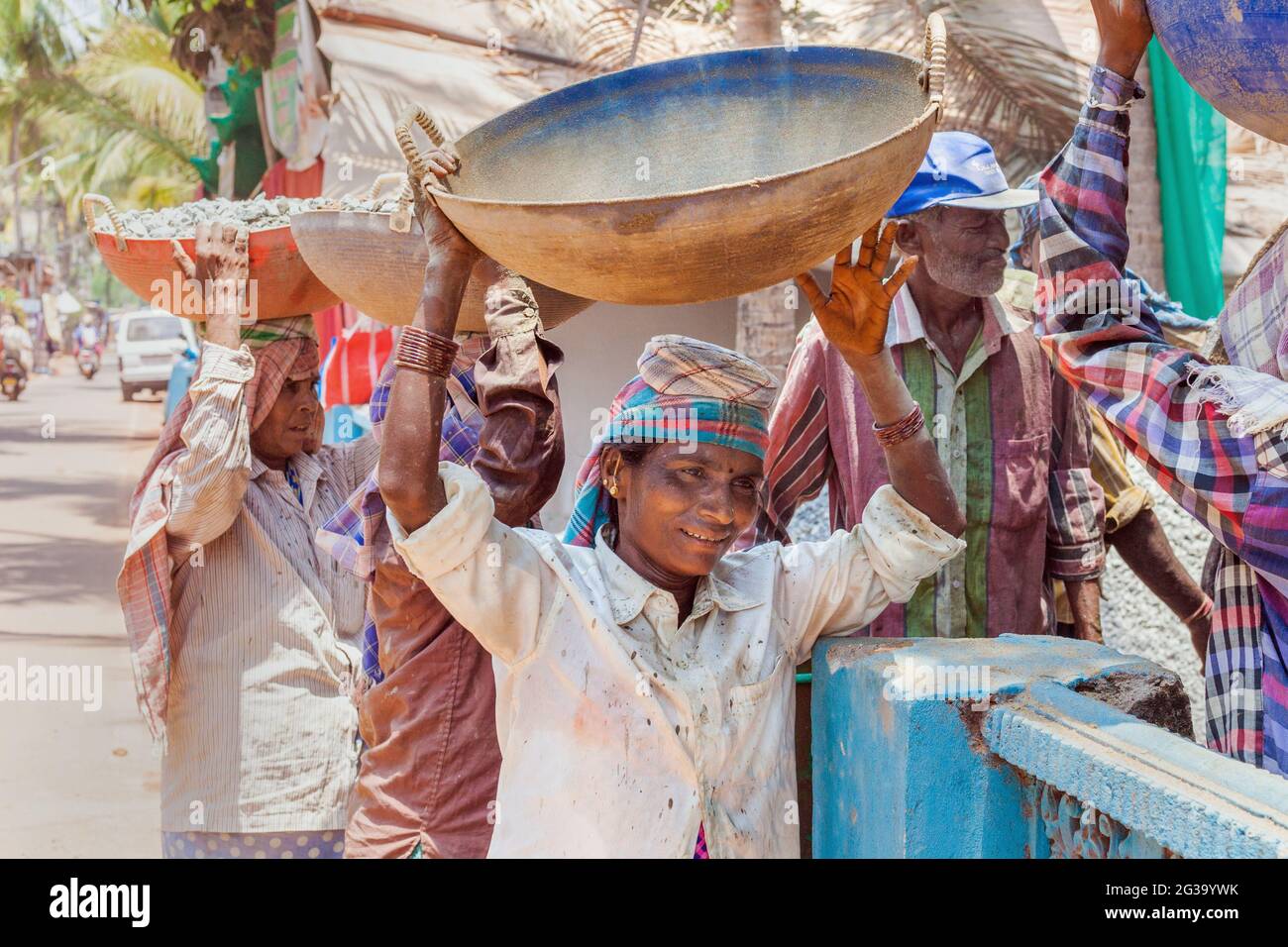 Female Indian manual labour workers carrying heavy loads on their heads
