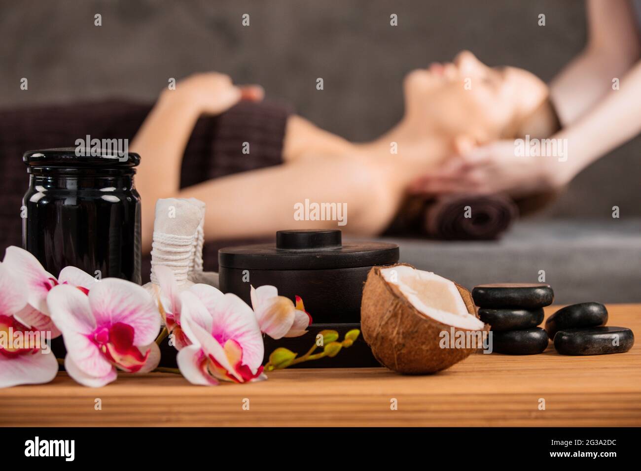 Beautiful woman getting head massage in spa orchid flowers coconut and  stones Stock Photo - Alamy