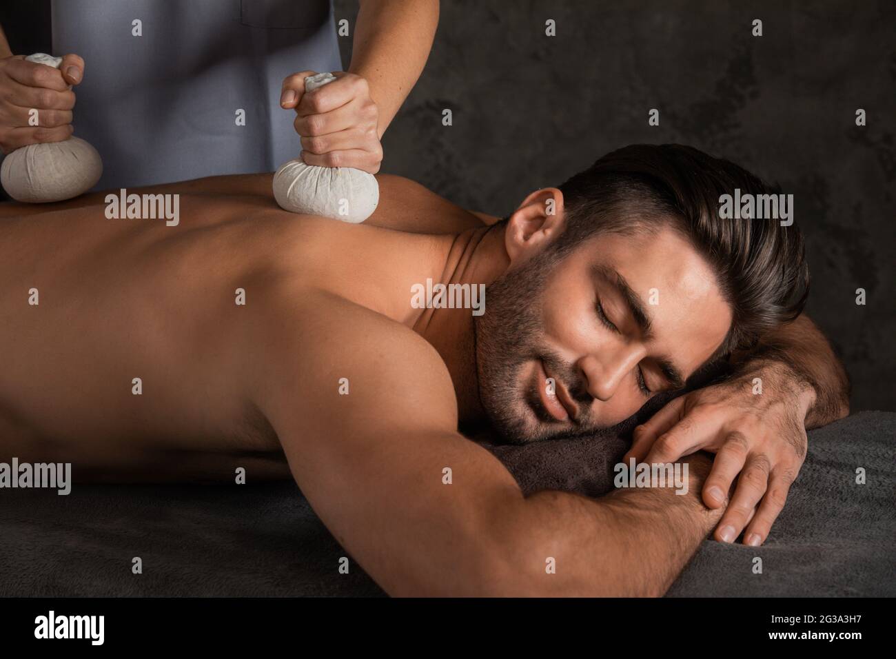 Young handsome man having back massage with pouche Stock Photo
