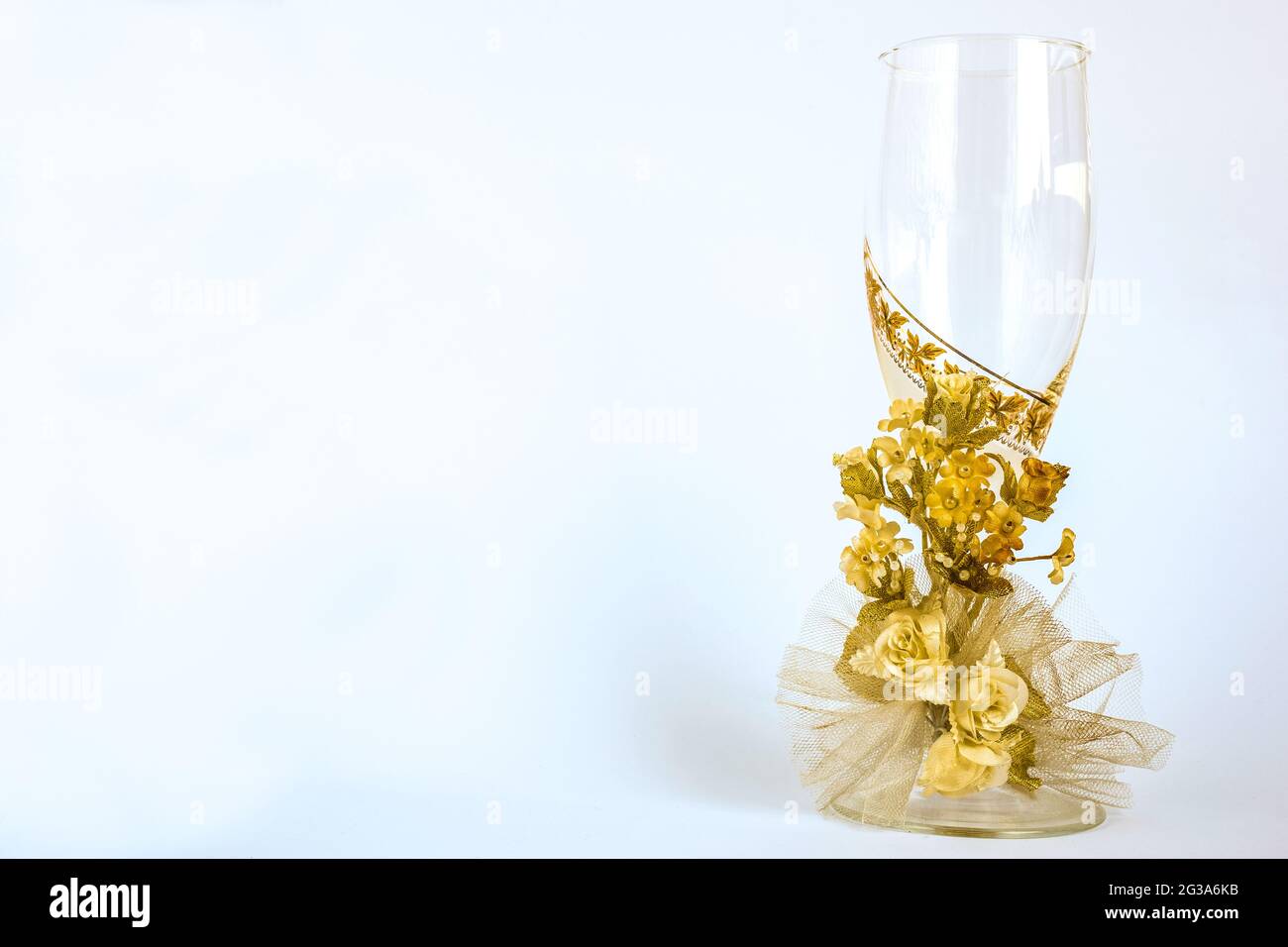 Empty champagne glass in a festive orange arrangement of flowers on a white background Stock Photo