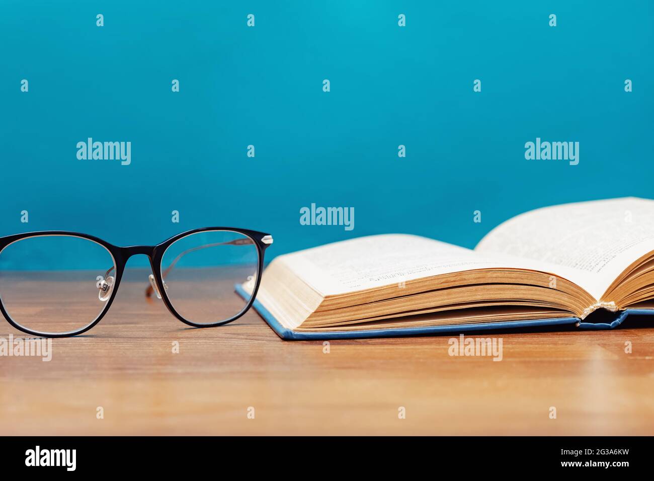 Close-up of reading glasses and opened book Stock Photo