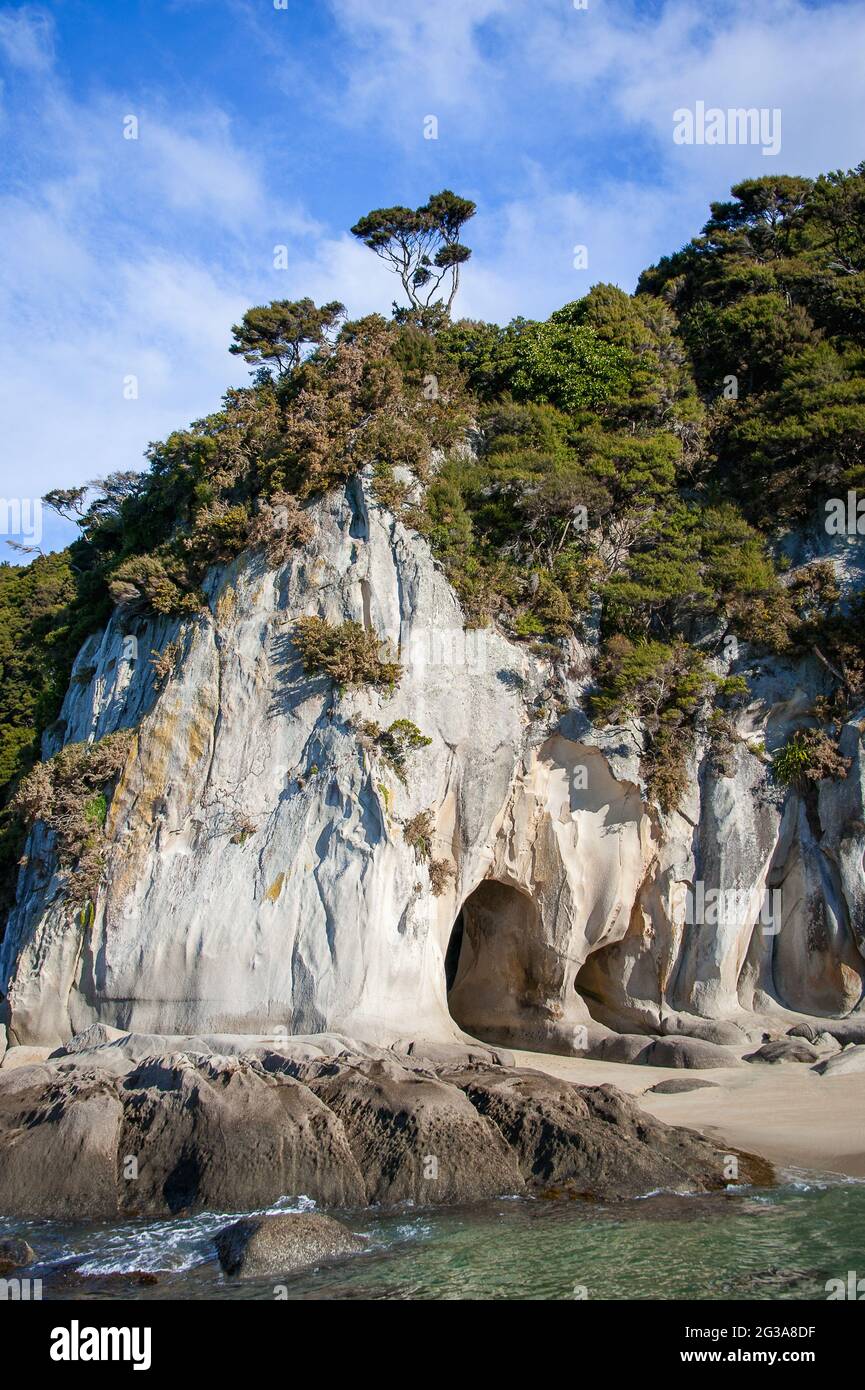 The Tonga Arches in Abel Tasman Marine Park, South Island, New Zealand. Iconic sea caves caused by erosion of the granite coastline in Tonga Bay. Stock Photo