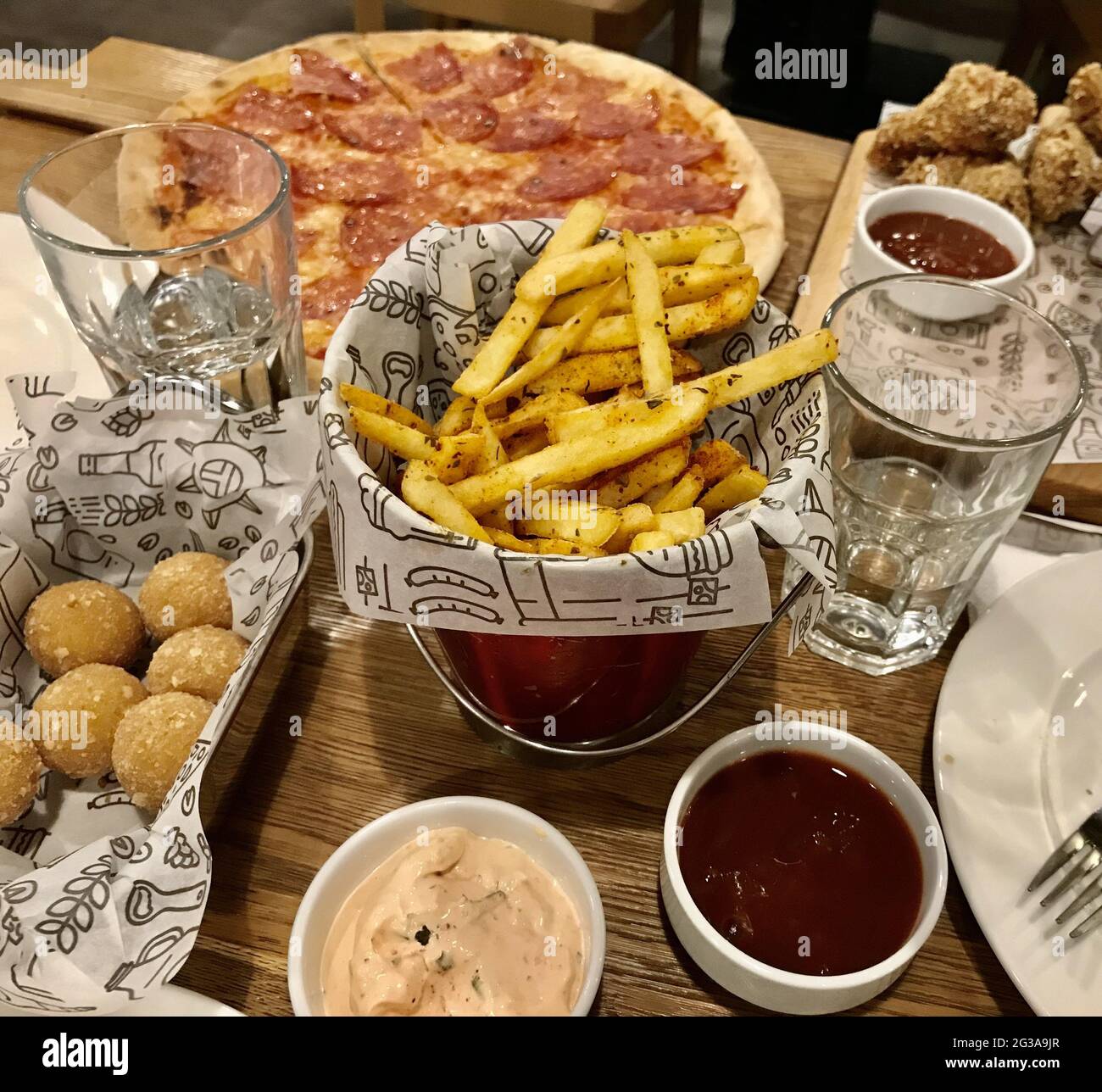Delicious dinner with crispy french fries, pepperoni pizza with cheese