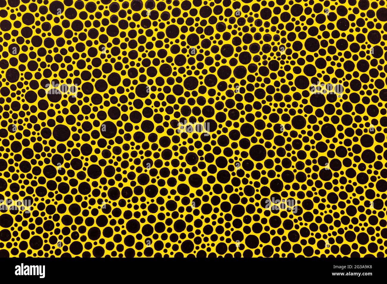 Close-up of Yayoi Kusama's black dots on yellow background painting at Victoria Miro gallery in 2016, London, UK Stock Photo
