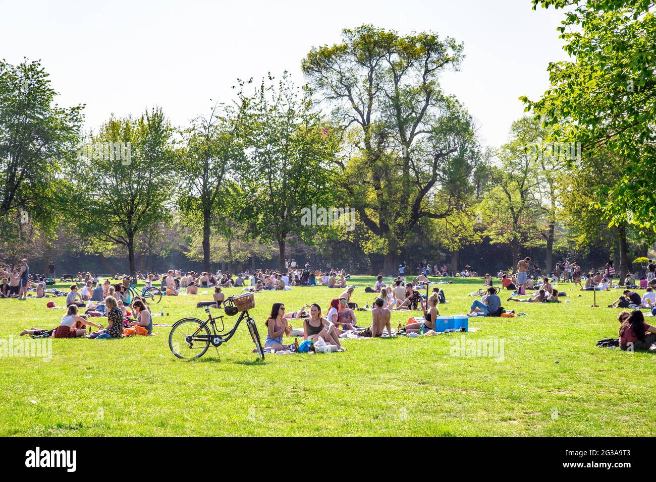 People sitting in the sun at Victoria Park, London, UK Stock Photo