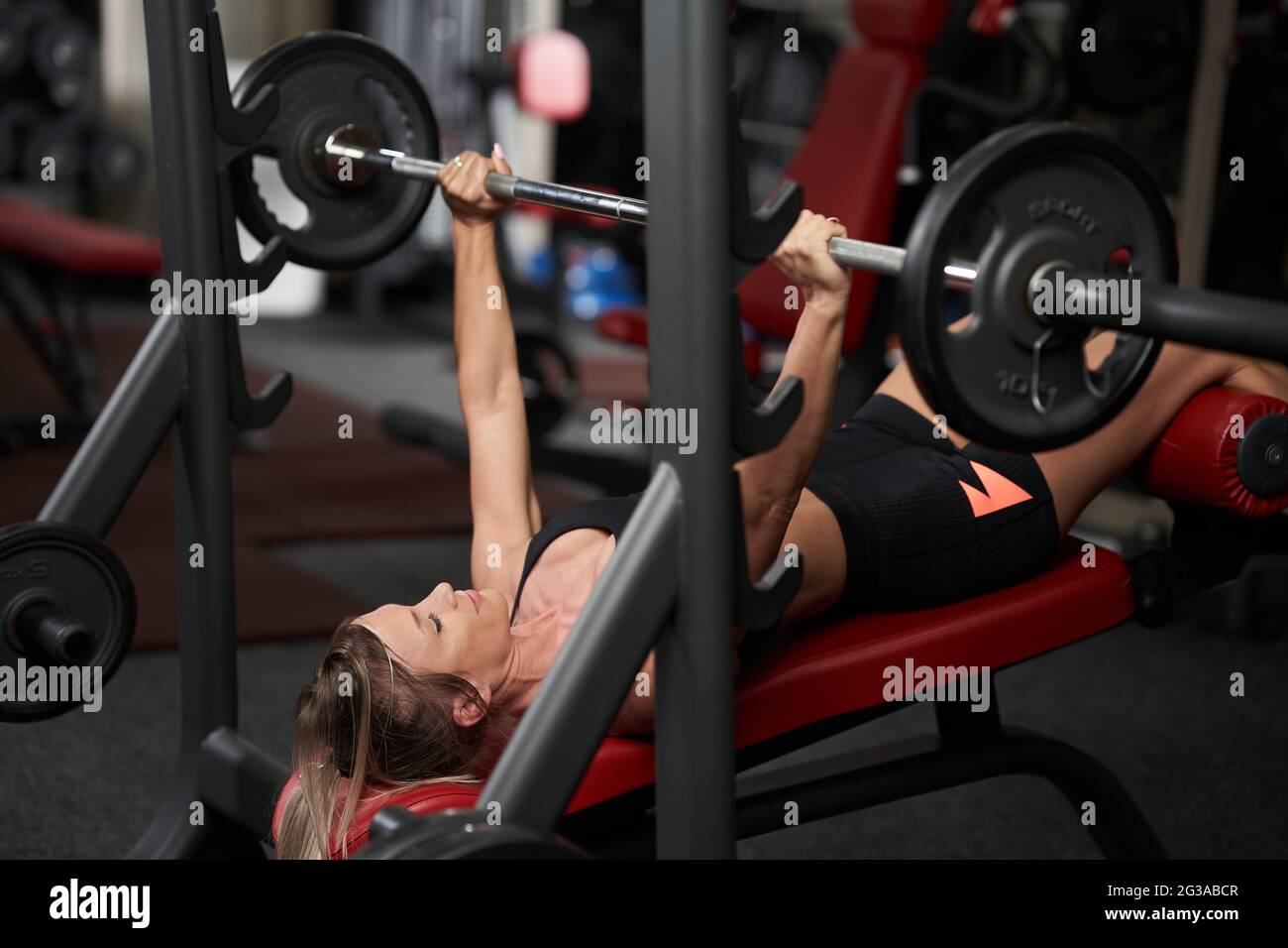 Young fitness woman doing incline bench press with barbell for chest workout Stock Photo Alamy