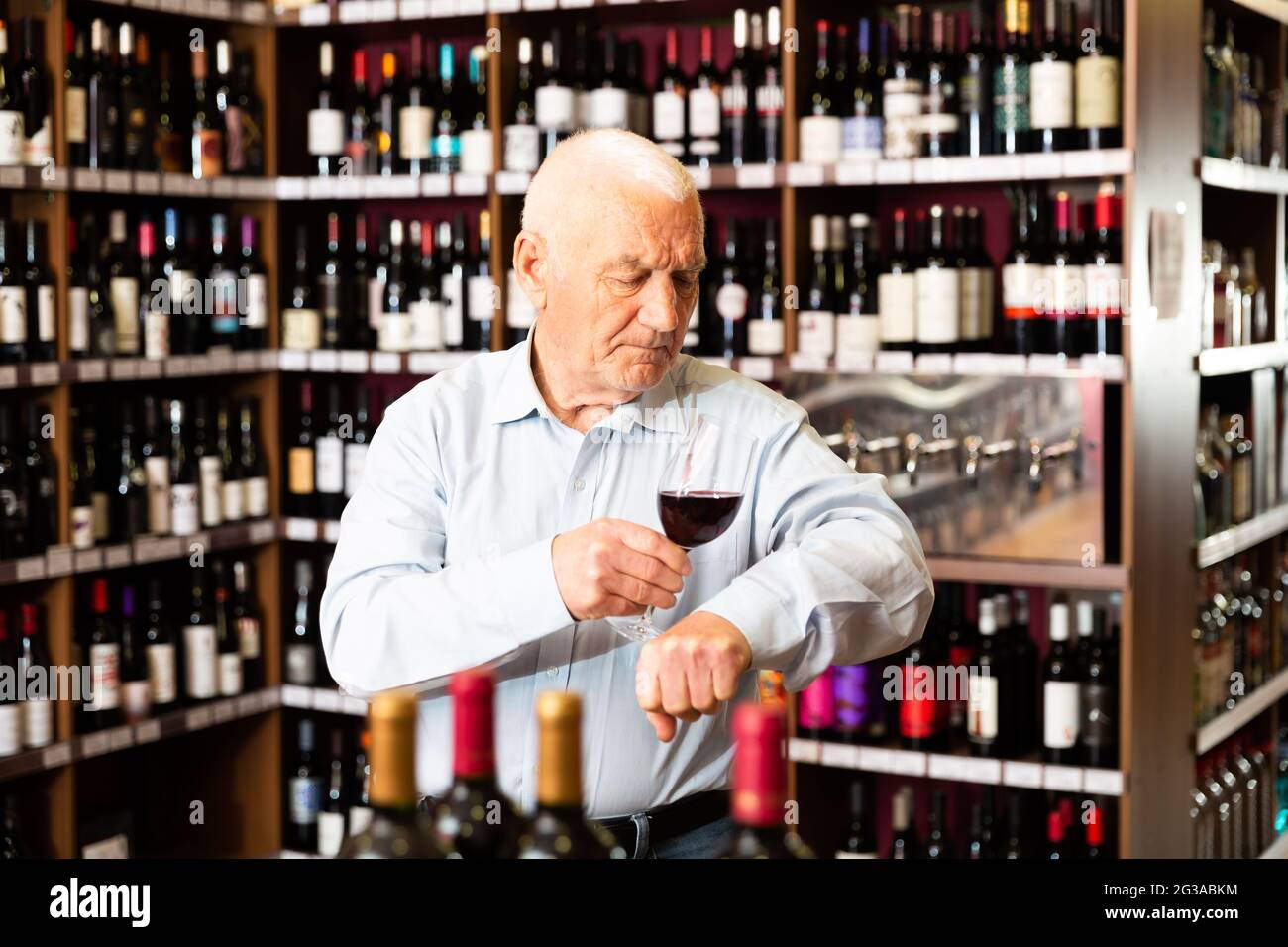 Portrait of senior man tasting red wine at wine shop Stock Photo - Alamy