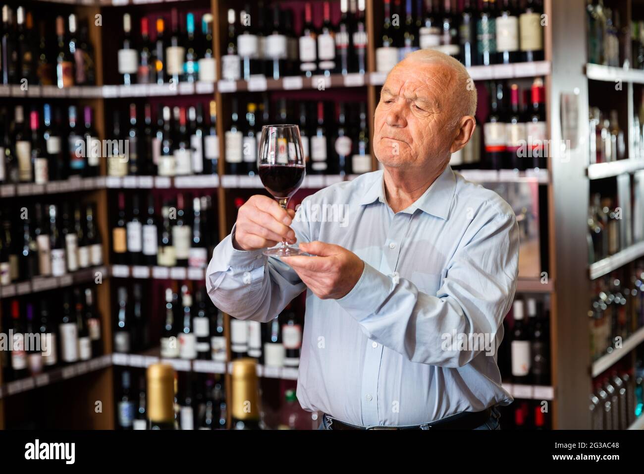 Portrait of senior man tasting red wine at wine shop Stock Photo - Alamy