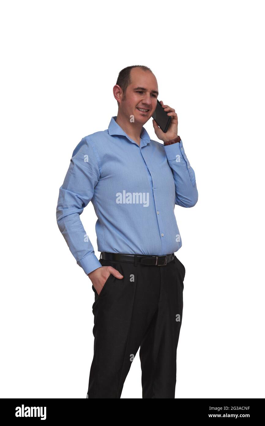Bald guy dressed in blue shirt and black pants having a conversation via his smartphone isolated on white background. May be an office worker or banke Stock Photo