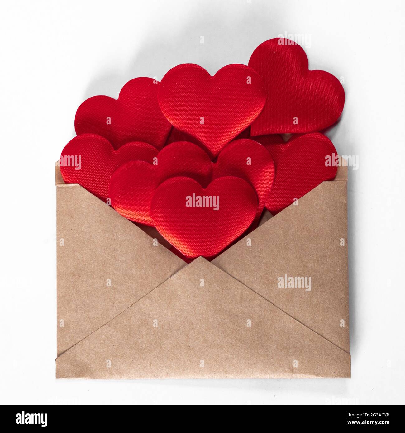 Valentine day love letter, envelope of craft paper with red hearts heap ...