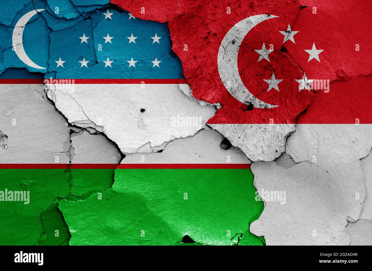 flags of Uzbekistan and Singapore  painted on cracked wall Stock Photo