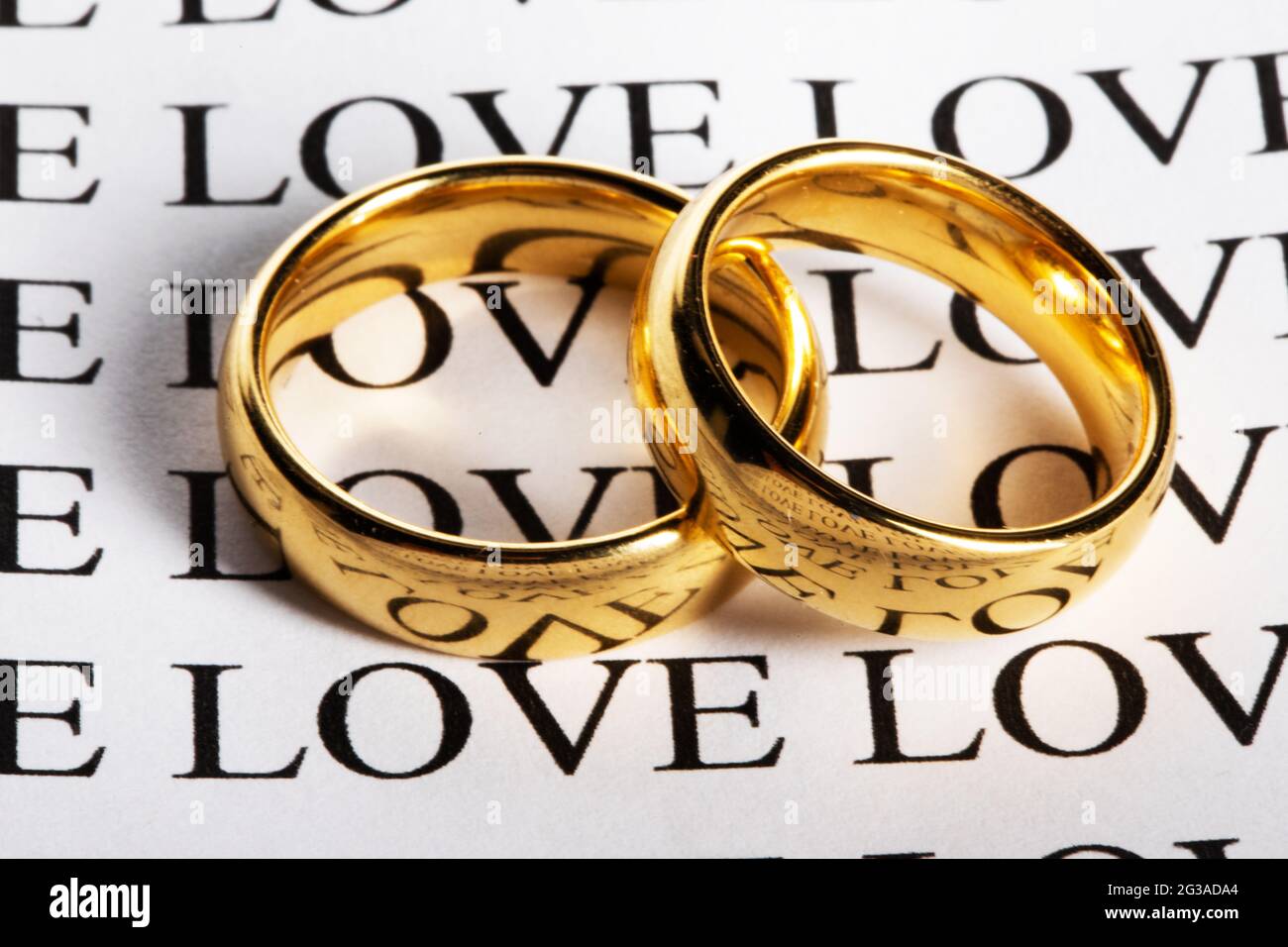 Two wedding rings made in gold and the word love Stock Photo - Alamy