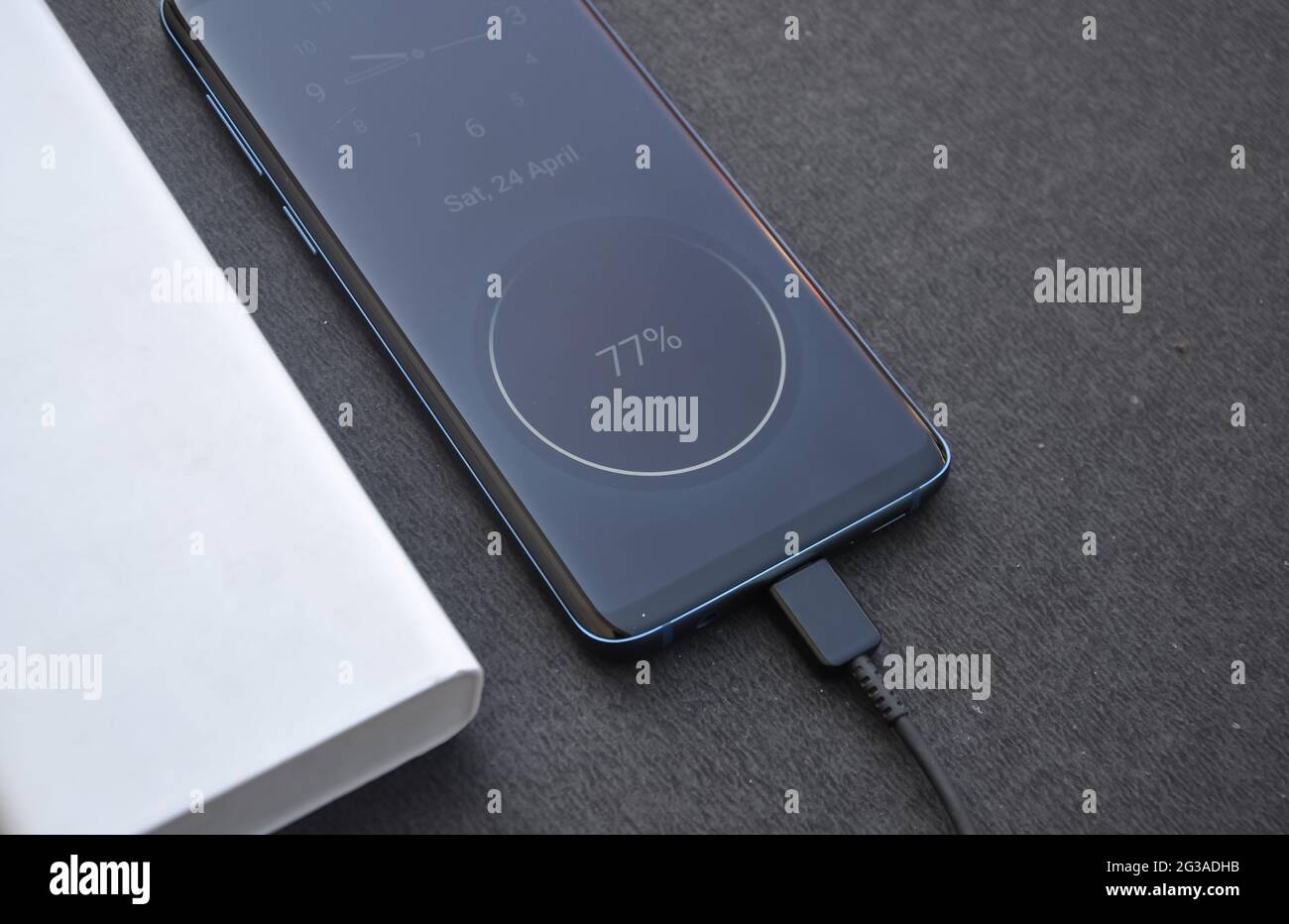 Photo of a black color smartphone connected with power bank for charge ...