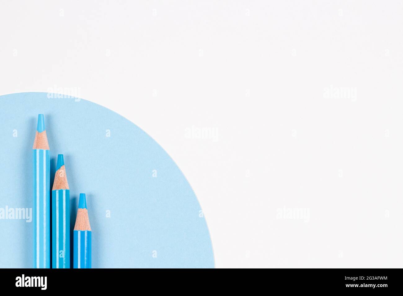Light blue colored pencils on geometric blue and white background