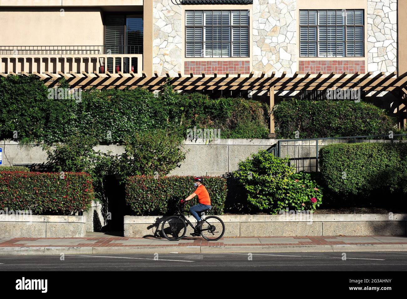 San Mateo, USA. 14th June, 2021. A man rides on the street in San Mateo, California, the United States, June 14, 2021. California Governor Gavin Newsom and government health officials announced the official reopening of the state from Tuesday following months of anticipation.The reopening means that vaccinated people in California can go maskless in public, there will be no more limitations on out-of-state travelers, and California retail businesses can go back to full capacity. Credit: Wu Xiaoling/Xinhua/Alamy Live News Stock Photo