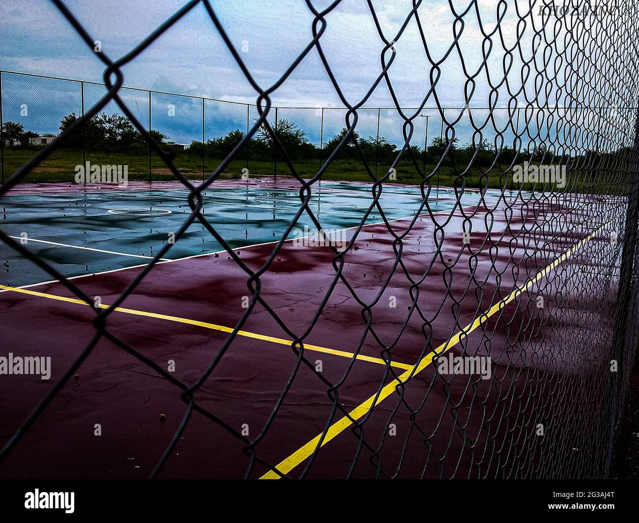 Netball or basketball wet emptycourt on a gloomy rainy day from behind