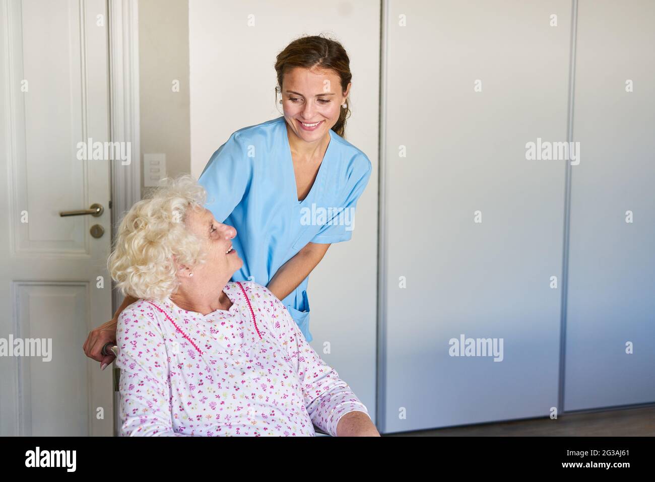Geriatric nurse takes care of senior citizens in wheelchairs in nursing
