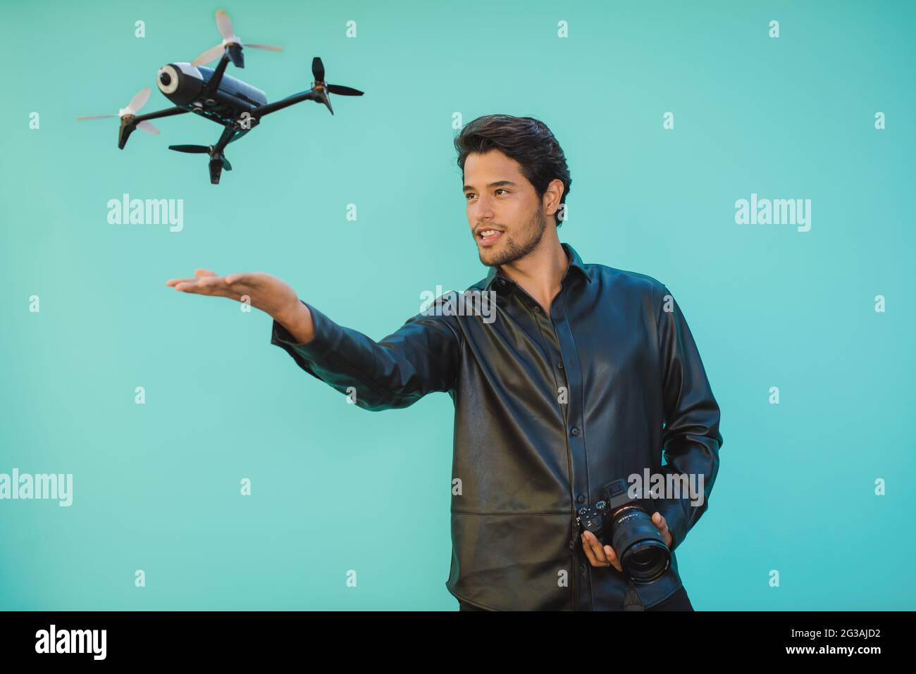 Masculine man with digital photo camera and flying drone Stock Photo