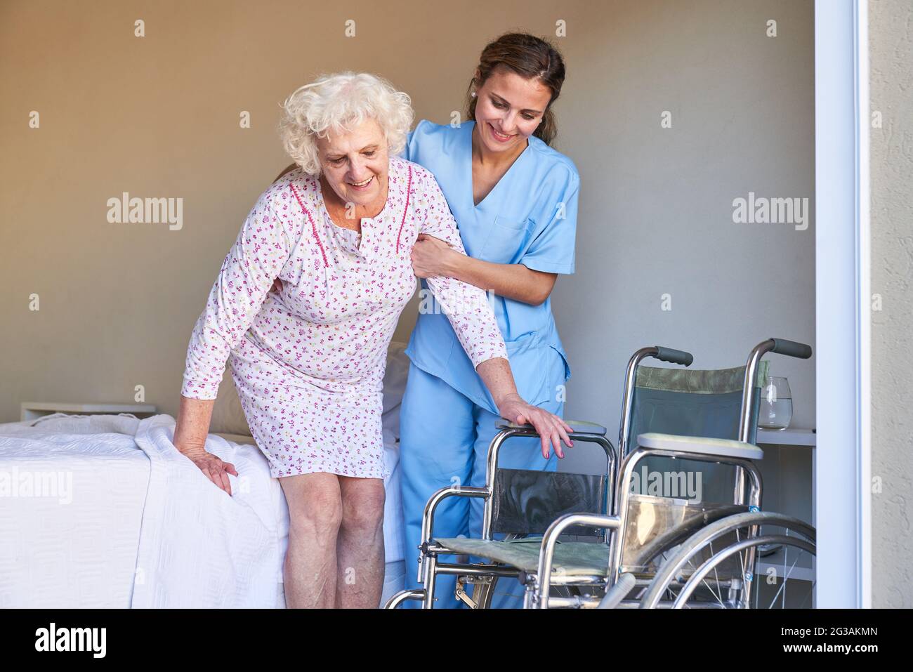 Elderly care worker helps senior citizen to get out of bed into a