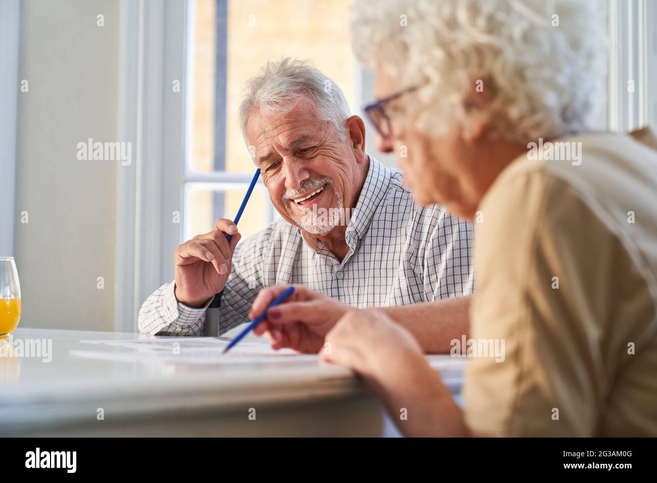 Couple of seniors has fun solving puzzles as a memory training against