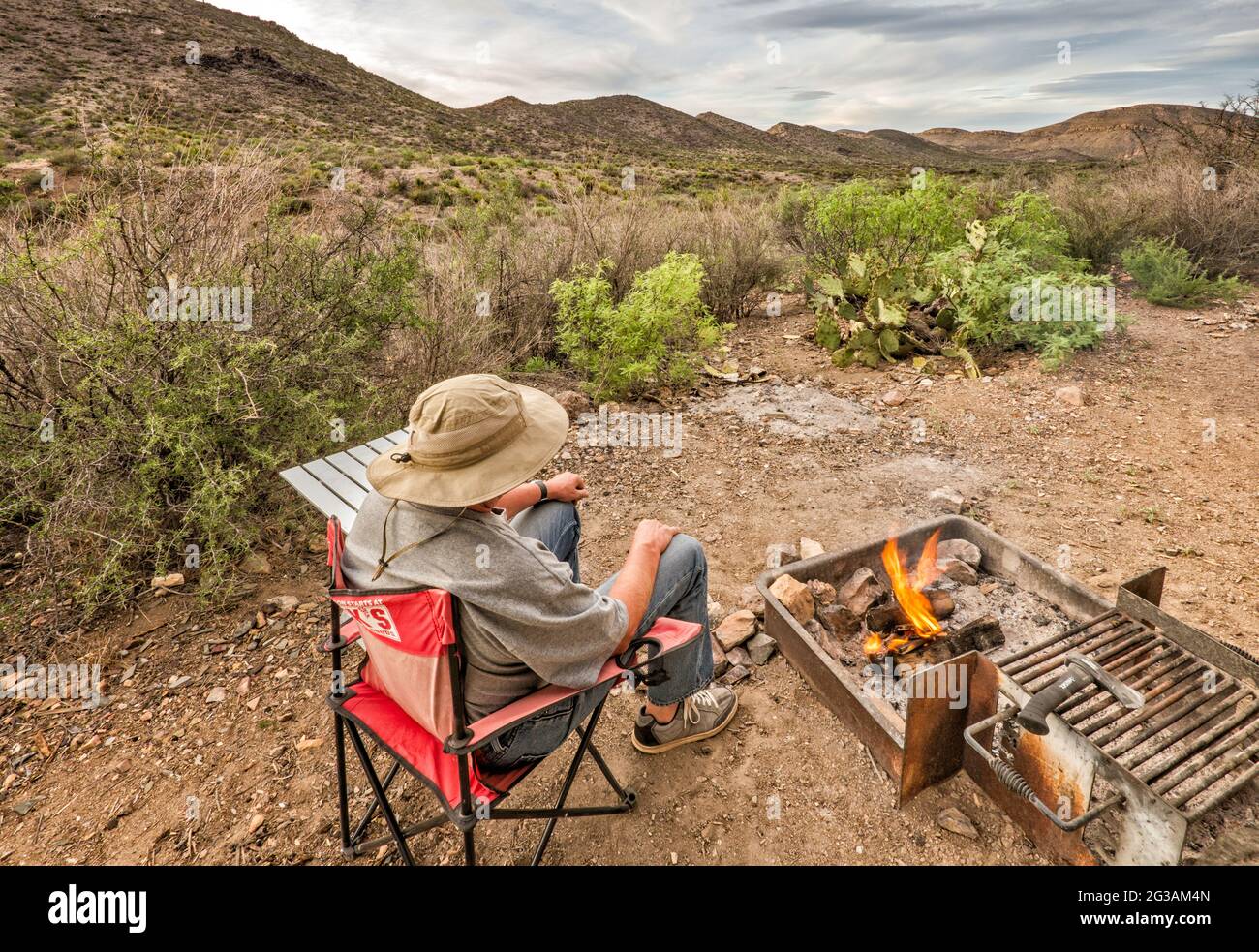 Camper relaxing at Tres Papalotes, campsite in El Solitario area, collapsed and eroded volcanic dome, Big Bend Ranch State Park, Texas, USA Stock Photo