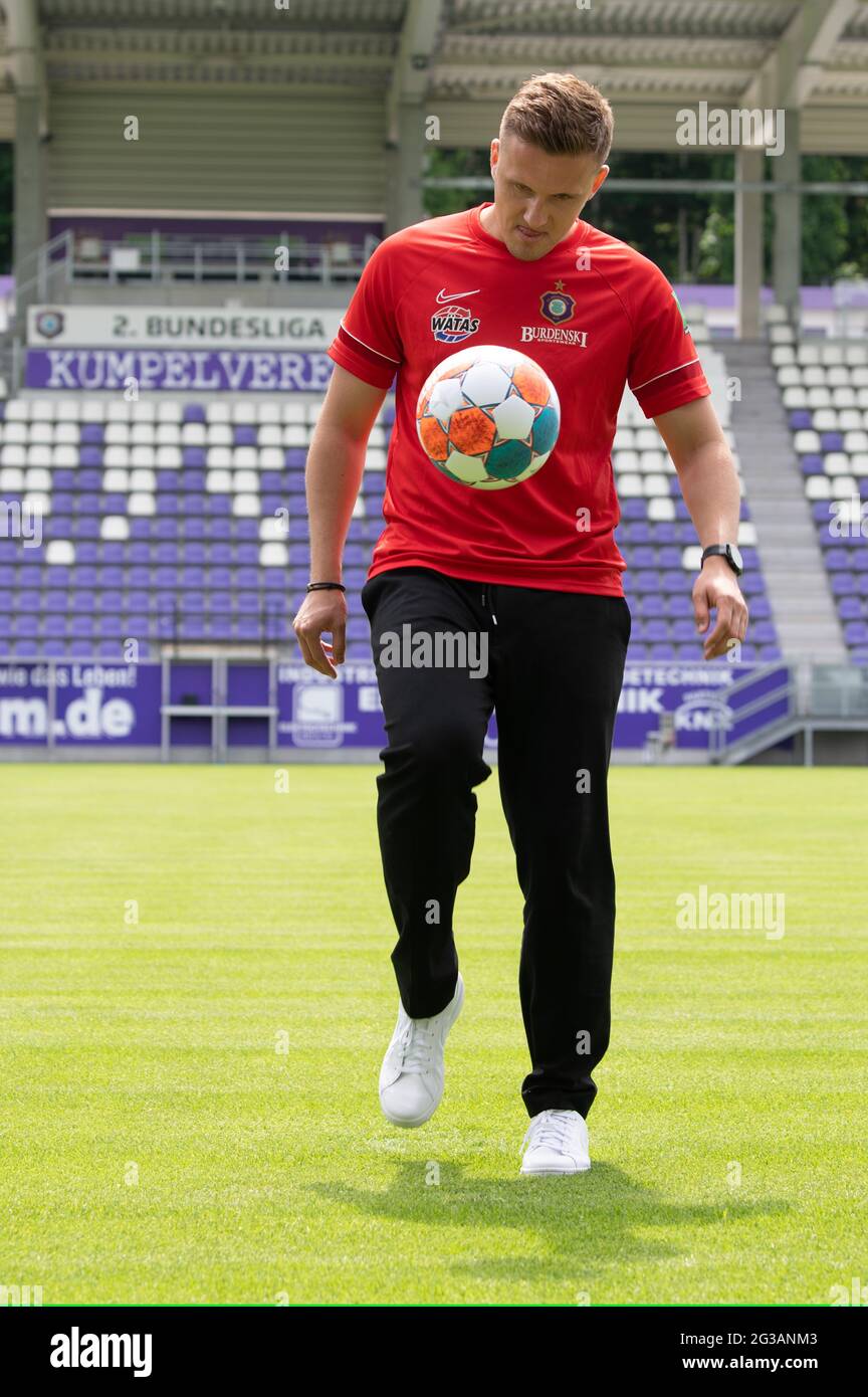 15 June 2021, Saxony, Aue: Aliaksei Shpileuski, coach of FC Erzgebirge Aue,  juggles a football on the sidelines of a press conference at the Erzgebirge  stadium. The Belarus-born coach has signed a