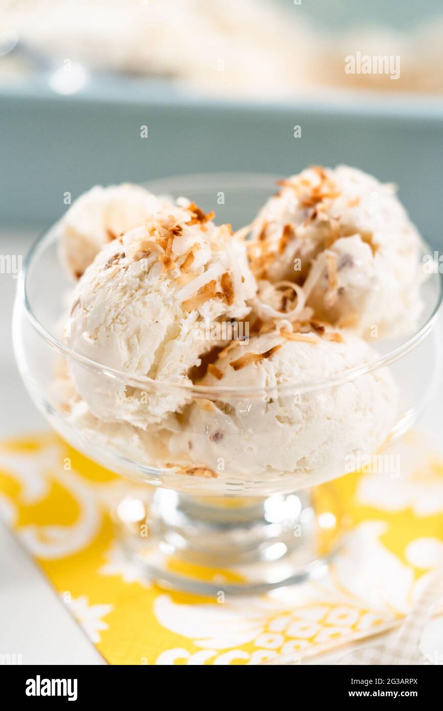 Homemade coconut ice cream garnished with roasted coconut flakes in a