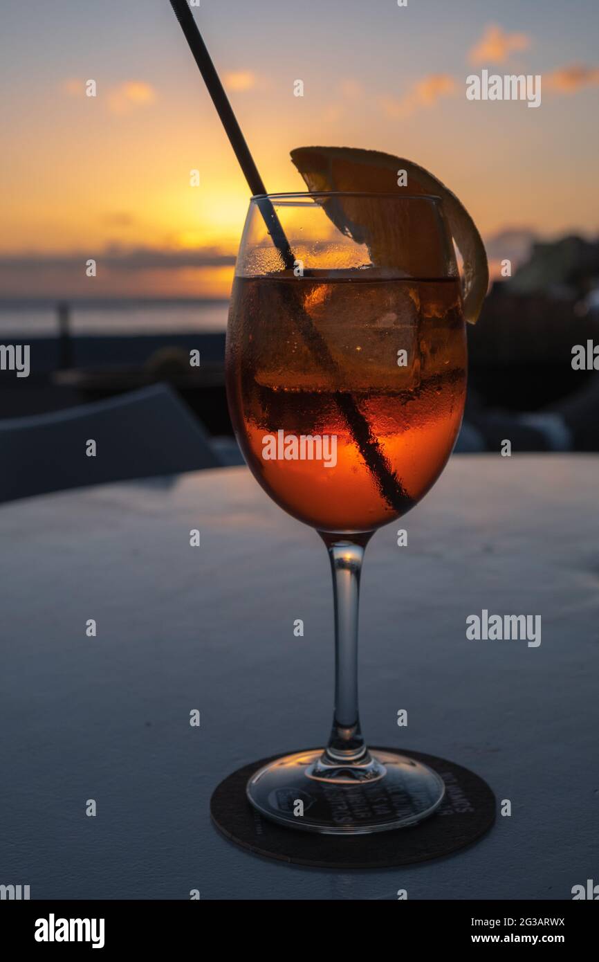 Aperol Spritz Cocktail am Strand bei Sonnenuntergang Stock Photo