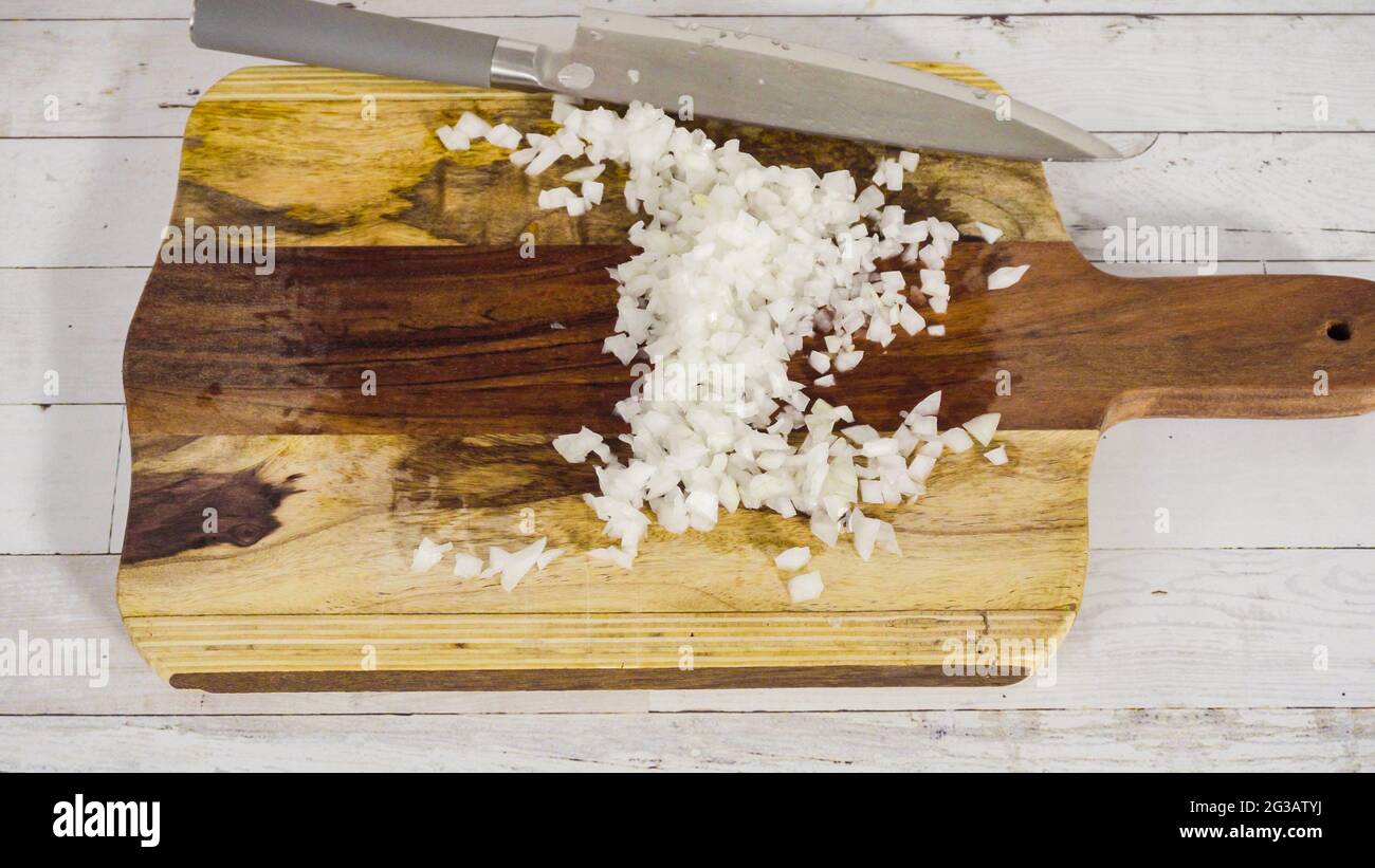 Mincing organic yellow onion on a wood cutting board Stock Photo Alamy