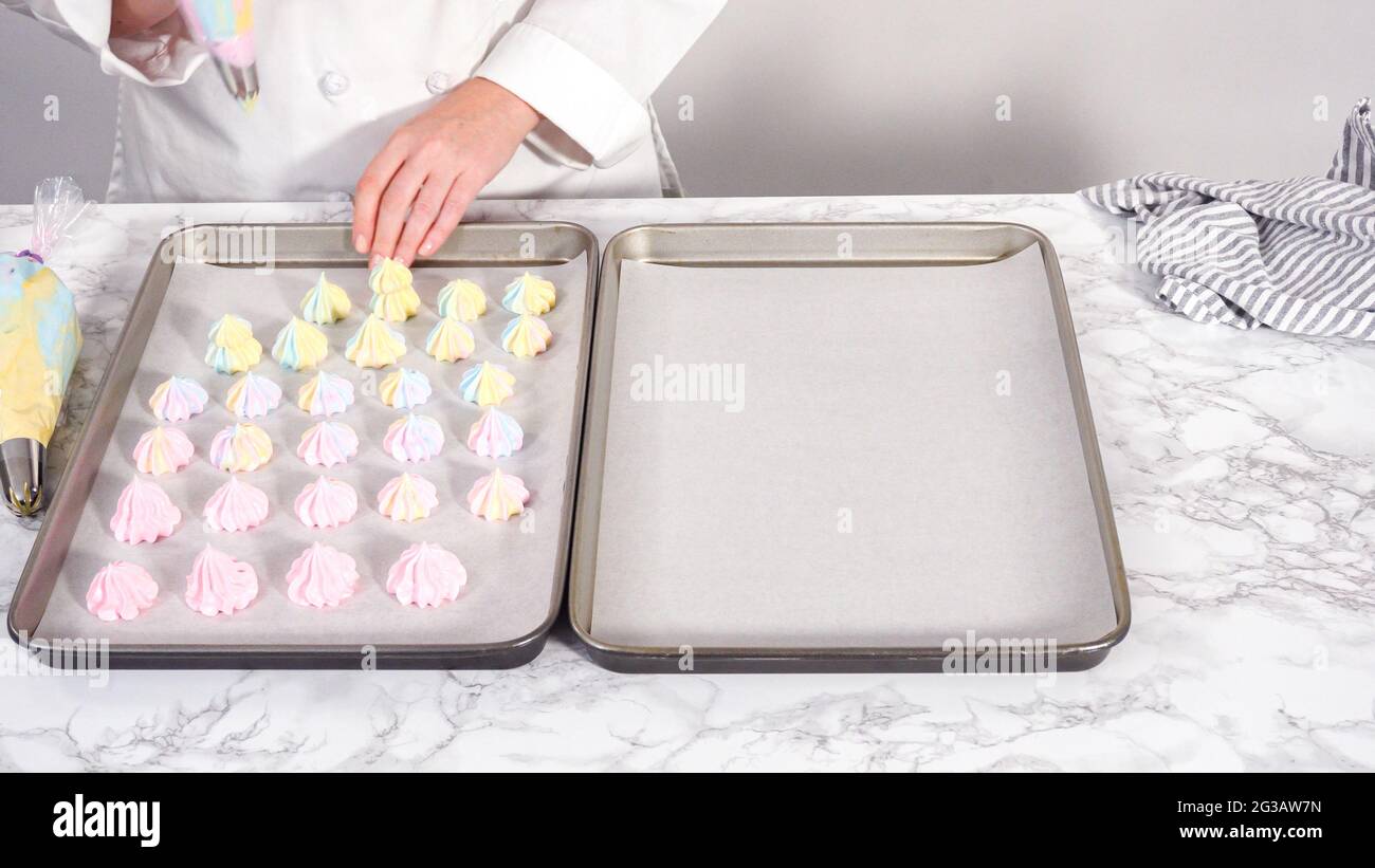 Step by step. Piping unicorn meringue cookies to the baking sheet lined with a parchment paper
