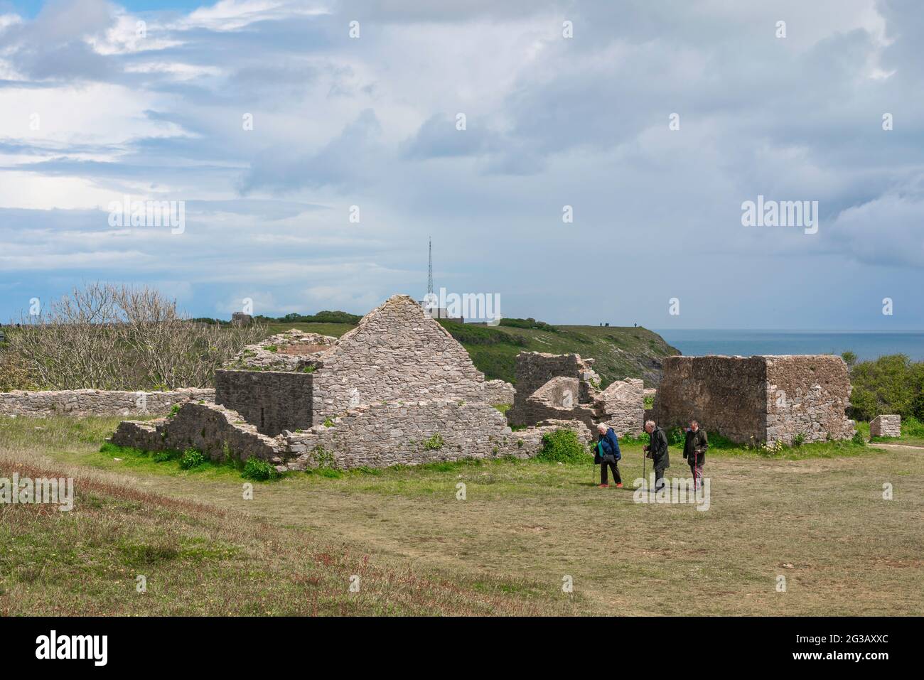 Senior people walking, view of three elderly friends walking in the ruins of the Southern Fort at Berry Head in Torbay, Devon, England, UK Stock Photo