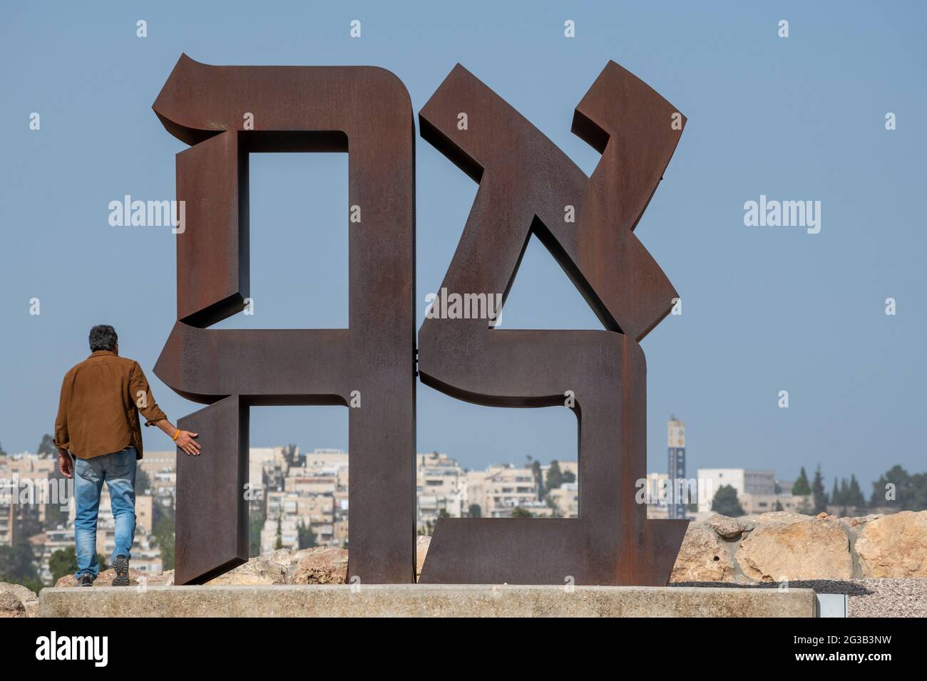 Israeli visitor exploring the famous AHAVA (love in Hebrew), Cor-ten steel 12-foot high sculpture by Robert Indiana at Israel Museum. Jerusalem Stock Photo