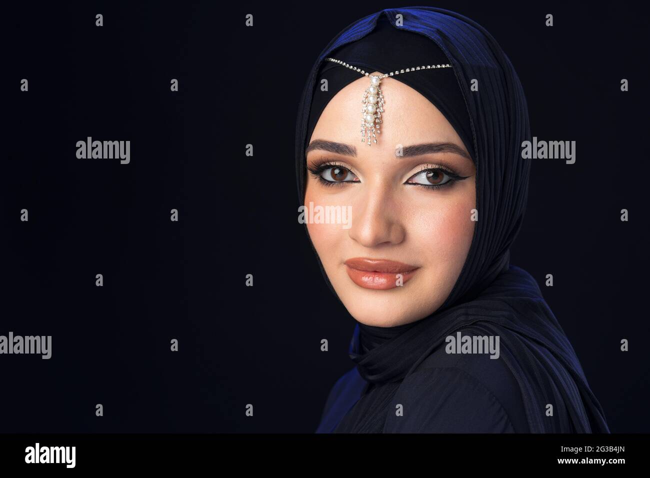 Portrait of a young muslim woman in hijab on black background Stock ...
