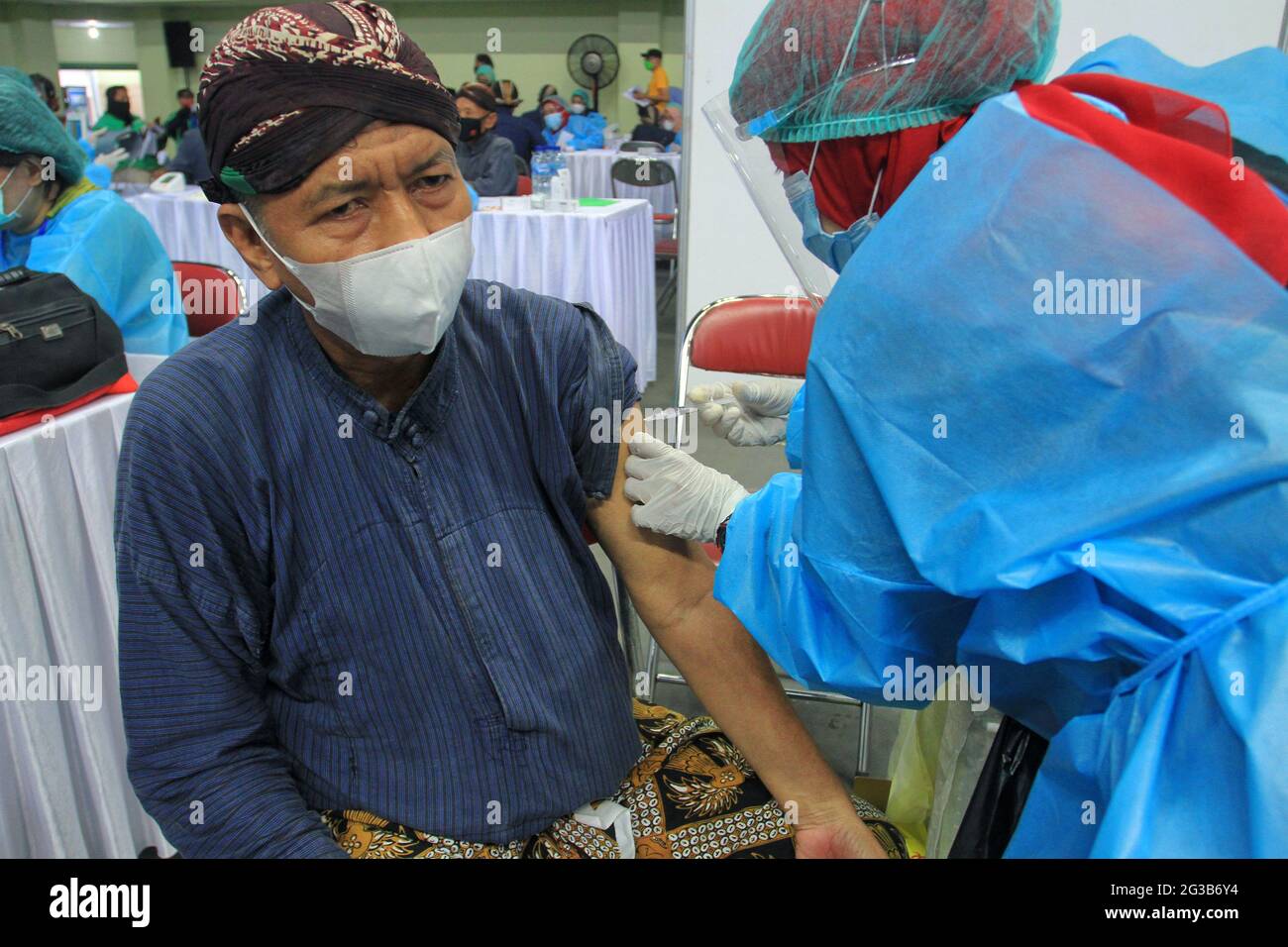 (210615) -- YOGYAKARTA, June 15, 2021 (Xinhua) -- A health worker administers a dose of COVID-19 vaccine to a man in Yogyakarta, Indonesia, June 15, 2021. Due to the surging increase of COVID-19 cases over the past few days in the country, Indonesia resorted to boosting the vaccination program against the lingering coronavirus disease. (Photo by Joni/Xinhua) Stock Photo