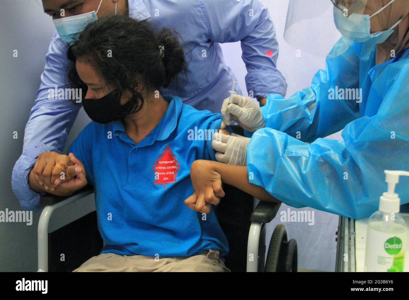 (210615) -- YOGYAKARTA, June 15, 2021 (Xinhua) -- A health worker administers a dose of COVID-19 vaccine to a girl in Yogyakarta, Indonesia, June 15, 2021. Due to the surging increase of COVID-19 cases over the past few days in the country, Indonesia resorted to boosting the vaccination program against the lingering coronavirus disease. (Photo by Joni/Xinhua) Stock Photo