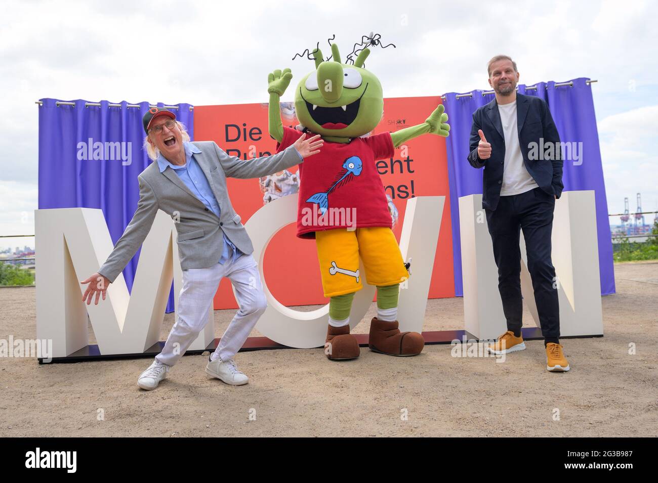 15 June 2021, Hamburg: Otto Waalkes (l-r), comedian, actor and director, poses at a press event with a character from the animated film 'Die Olchis' and Helge Albers, film producer and Managing Director of Moin Filmförderung Hamburg Schleswig-Holstein GmbH, in front of the lettering 'Moin'. On the occasion of the nationwide cinema release on 01 July 2021, MOIN Filmförderung Hamburg Schleswig-Holstein is luring viewers back into the halls with free cinema tickets. Photo: Jonas Walzberg/dpa Stock Photo
