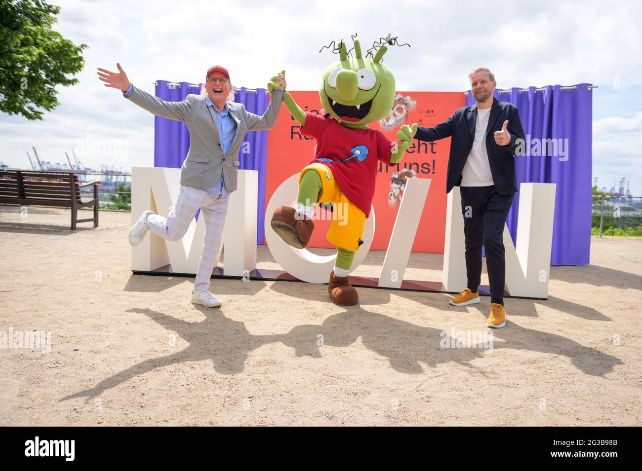 15 June 2021, Hamburg: Otto Waalkes (l-r), comedian, actor and director, poses at a press event with a character from the animated film 'Die Olchis' and Helge Albers, film producer and Managing Director of Moin Filmförderung Hamburg Schleswig-Holstein GmbH, in front of the lettering 'Moin'. On the occasion of the nationwide cinema release on 01 July 2021, MOIN Filmförderung Hamburg Schleswig-Holstein is luring viewers back into the halls with free cinema tickets. Photo: Jonas Walzberg/dpa Stock Photo