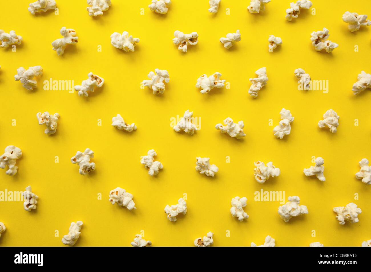 Popcorn scattered on yellow background. Popcorn pattern. top view. Stock Photo