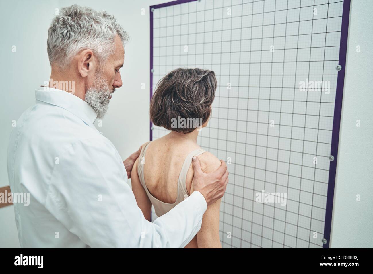 Doctor assessing the spinal alignment from a posterior view Stock Photo