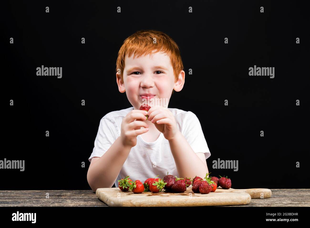 Young boy eating strawberry hires stock photography and images Alamy
