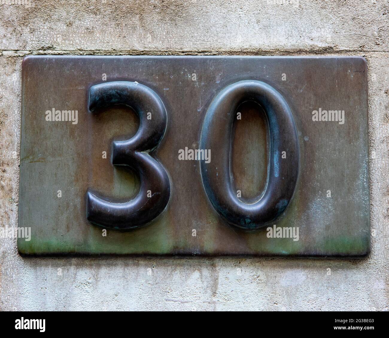 A brass plaque portraying the Number 30. Stock Photo