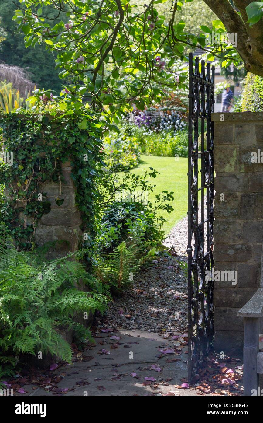An open garden gate in an English cottage garden. Stock Photo