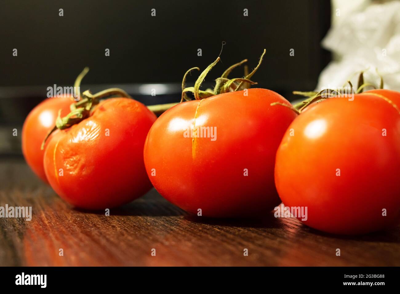 Branch with ripe red tomatoes on the table close up Stock Photo - Alamy