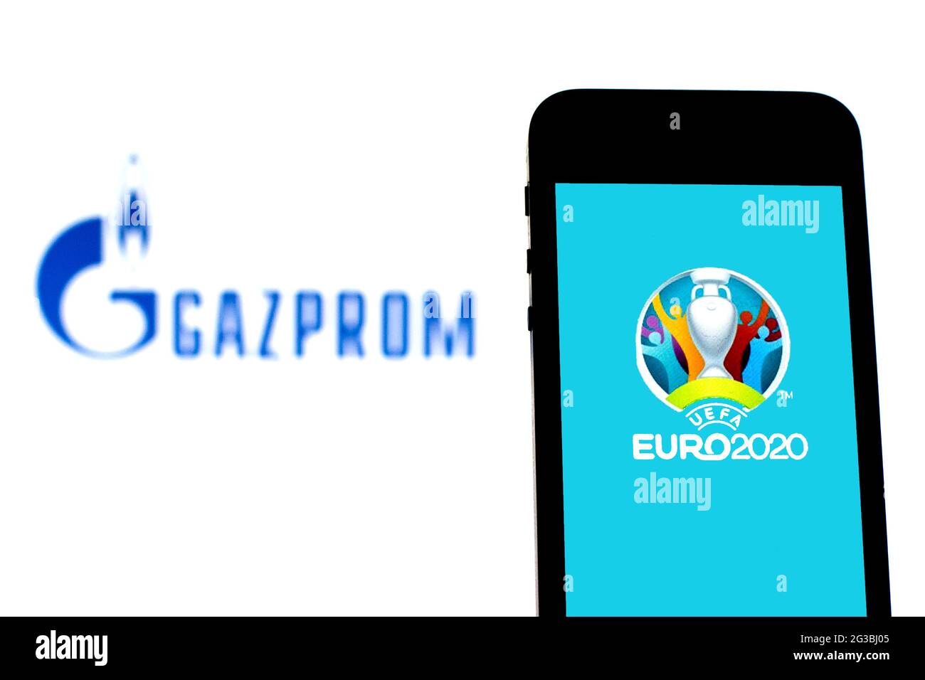 In this photo illustration a UEFA Euro 2020 logo seen displayed on a smartphone with a Gazprom logo in the background. Stock Photo