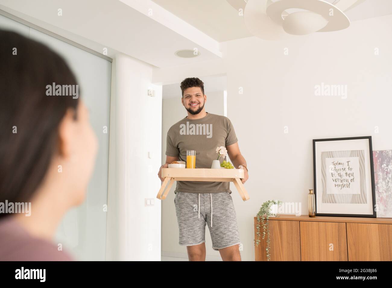 Happy young man carrying tray with breakfast for his wife Stock Photo