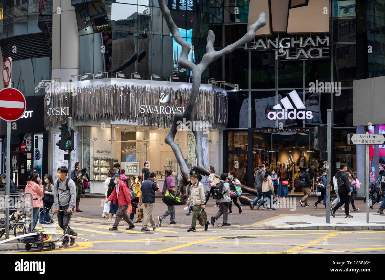 Pedestrians cross the street in front of German multinational sportswear brand  Adidas and Austrian jewelry producer and luxury brand Swarovski stores in  Hong Kong Stock Photo - Alamy