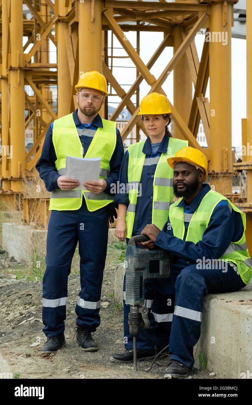 Three intercultural builders in uniform on construction site Stock Photo