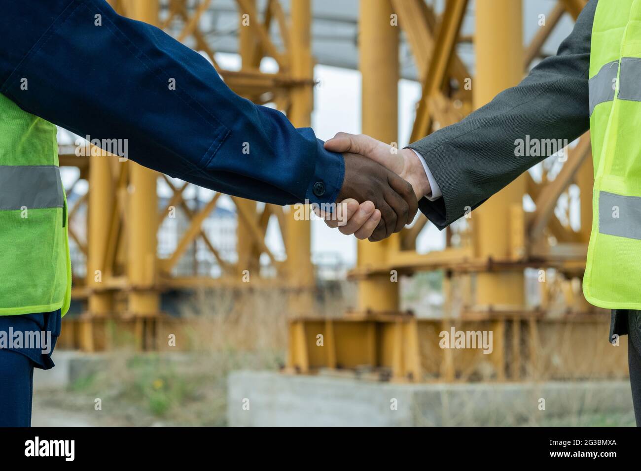 Handshake of engineers of African and Caucasian ethnicities against ...